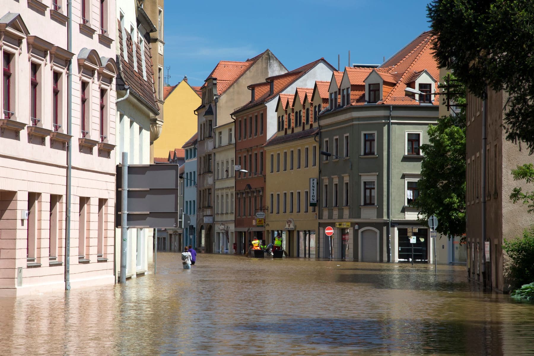 Flooded town street with a response crew working in high-visibility gear